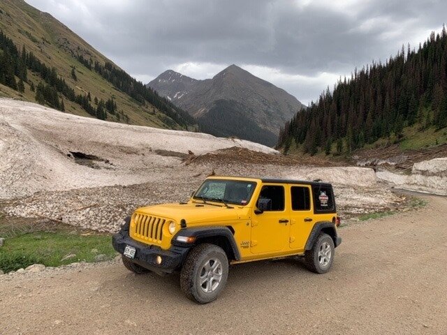 yellow Jeep on dirt road
